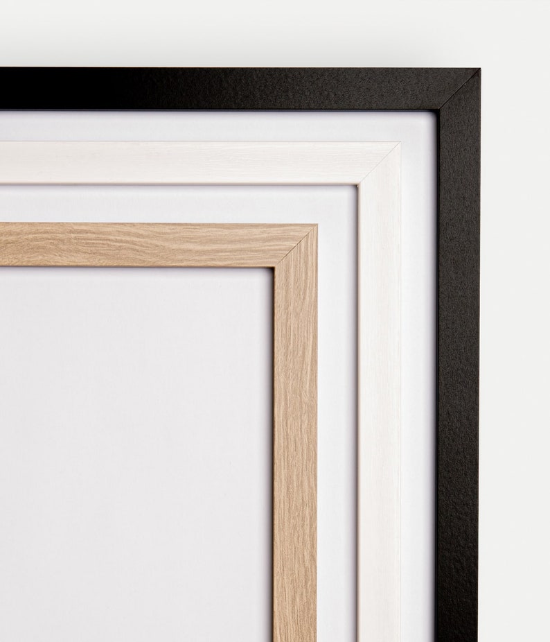 May include: A triple matted picture frame with a black outer frame, a white middle frame, and a natural wood inner frame.