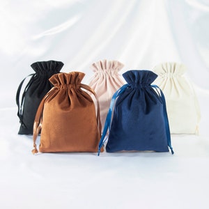 Pode incluir: Cinco sacos de cord&atilde;o de diferentes cores e tecidos. Os sacos s&atilde;o feitos de veludo, algod&atilde;o e linho. Todos est&atilde;o fechados e t&ecirc;m um fecho de cord&atilde;o.