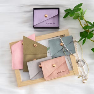 Novo estilo 50 peças bolsa de joias de microfibra com botão bolsa de joias logotipo em relevo personalizado embalagem de anel e colar