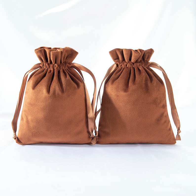 Pode incluir: Duas bolsas de cord&atilde;o de veludo marrom com la&ccedil;os de fita de cetim marrom combinando.