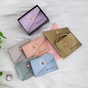 Novo estilo 100 peças de bolsa para joias de microfibra com logotipo em relevo personalizado e botão, bolsa para joias, anel, colar e embalagem