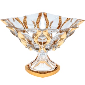 May include: A clear glass bowl with a gold rim and a gold-trimmed pedestal base. The bowl has a starburst design.