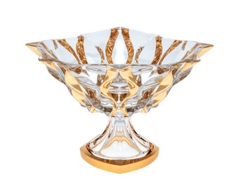 May include: A clear glass bowl with a gold rim and a gold-trimmed pedestal base. The bowl has a starburst design.