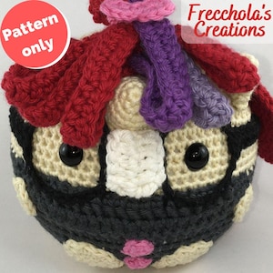 Può includere: Un oggetto a forma di gufo all'uncinetto con sezioni nere, crema e grigie. Ha grandi occhi neri a bottone, un becco bianco e una bocca rosa. Il gufo ha accenti di filo rosso, viola e rosa. Il testo "Pattern only" è in un cerchio rosso.