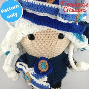 May include: Crochet doll pattern, featuring a white crocheted hat with blue and white stripes, a blue crocheted jacket, and a white crocheted skirt. The doll has black eyes and a beige face.