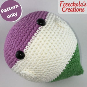May include: Crocheted plush toy in the shape of a heart with purple, white, and green sections. The toy has two black button eyes.