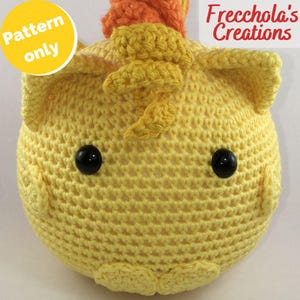 May include: A crocheted yellow chick with black button eyes and an orange and yellow crest. The chick has a round shape and is handmade. The text "Pattern only" is in a yellow circle. The text "Frecchola's Creations" is in the upper right corner.