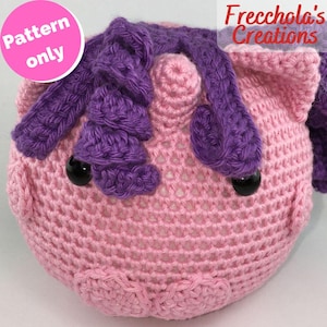 Può includere: Testa di unicorno all'uncinetto fatta a mano, nei toni del rosa e del viola. L'unicorno ha occhi a bottone neri e una criniera e orecchie dettagliate. L'immagine include il testo "Pattern only" e "Freccola's Creations".