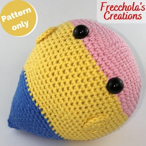 Può includere: Un giocattolo all'uncinetto a forma di lacrima con uno schema di colori giallo, blu e rosa. Il giocattolo ha due occhi di bottone neri.