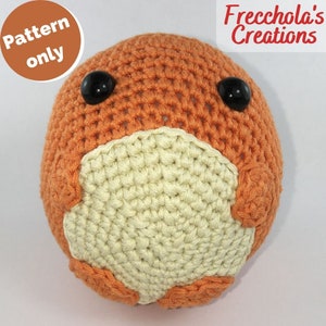 Può includere: Un giocattolo di peluche di colore arancione e crema lavorato a uncinetto con occhi neri. Il giocattolo ha la forma di una palla rotonda con una palla rotonda più piccola attaccata alla parte inferiore.