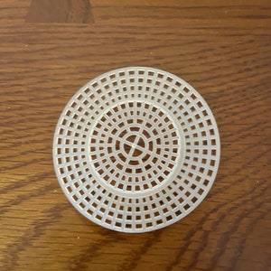 May include: White plastic circular loom with a grid pattern. The loom is designed for creating circular crafts.