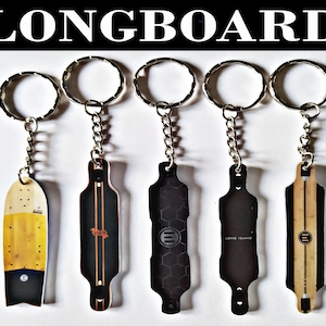 May include: A collection of longboard keyrings. The keyrings display miniature longboard designs in various styles, including a yellow and black design, and several black boards with different graphic patterns. Each keyring has a silver chain and ring.