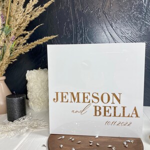 Op de afbeelding: Een wit bord met gouden letters dat de bruiloft van Jemeson en Bella op 10.11.2022 aankondigt.