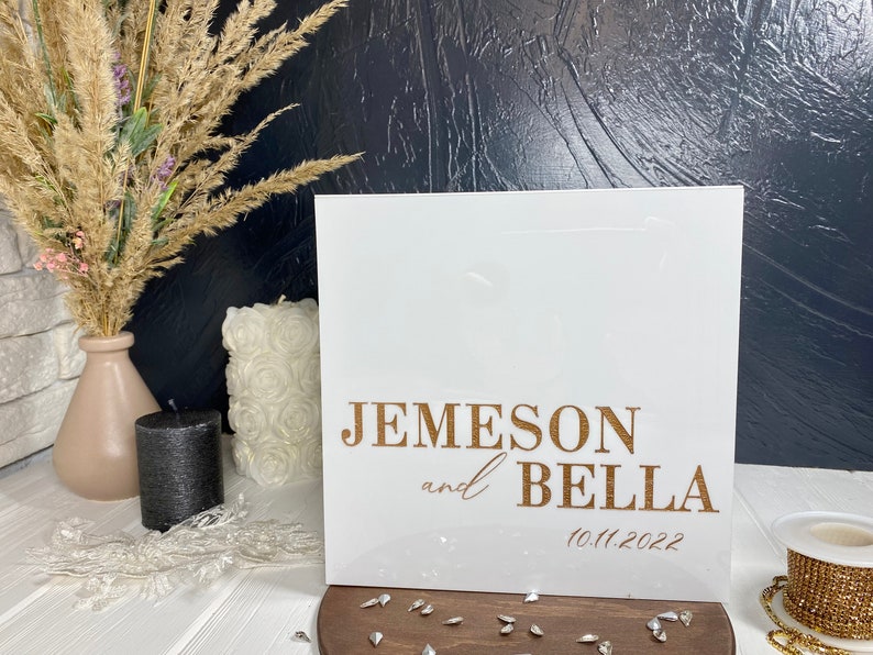 Op de afbeelding: Een wit bord met gouden letters dat de bruiloft van Jemeson en Bella op 10.11.2022 aankondigt.