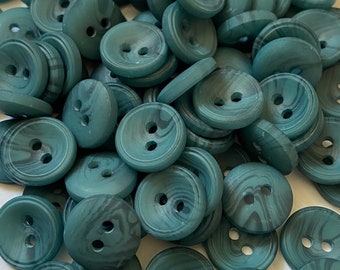 May include: A pile of teal green buttons with a marbled pattern. The buttons have two holes each.