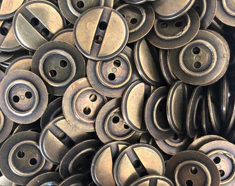 May include: A collection of antique brass-coloured buttons. The buttons are circular with two holes and a vertical groove. The buttons have a slightly aged appearance, suggesting vintage or retro styling. Suitable for sewing, crafts, or adding a unique touch to clothing.