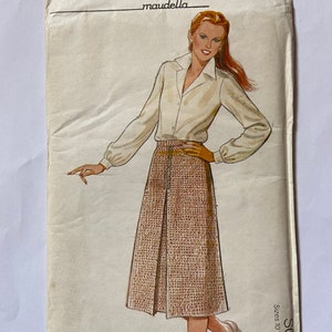 May include: A vintage sewing pattern for a skirt and blouse. The pattern is called "SO 16" and is for sizes 10, 12, 14, 16, and 18. The pattern is by "maudella" and is a multi-size pattern. The blouse is not included.