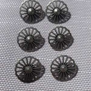 May include: Six silver metal buttons with a decorative, circular, sunburst design.