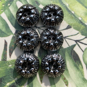 May include: Six silver-toned buttons with a raised, textured design. The buttons have two holes each and are arranged in two rows of three.