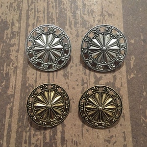 May include: Four decorative metal buttons with a starburst design. Two buttons are silver and two buttons are gold.