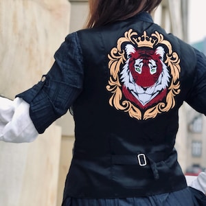 May include: Black satin vest with a gold embroidered design featuring a red and white tiger head with a crown above it.