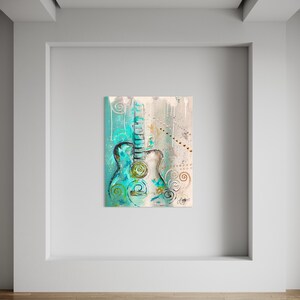 May include: Abstract painting of a teal blue acoustic guitar with gold and white accents. The guitar is surrounded by swirls and dots. The background is a light beige color.