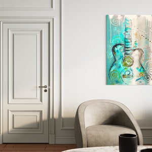 May include: Abstract painting of a teal and white acoustic guitar with swirls and dots on a light brown background.