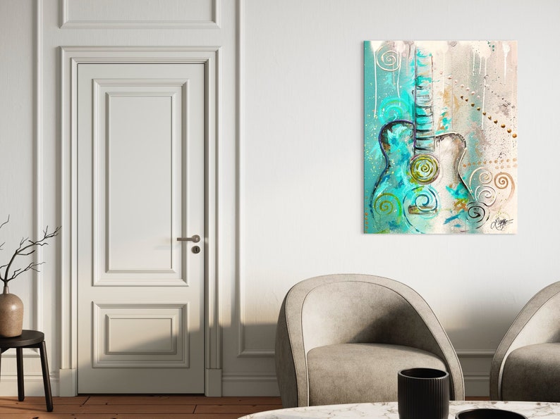 May include: Abstract painting of a teal and white acoustic guitar with swirls and dots on a light brown background.