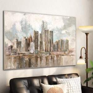 Neutral-toned abstract city skyline painting with skyscrapers and reflective water, displayed in a modern living room.