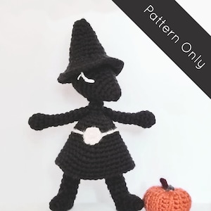 May include: Crochet pattern for a black and white character wearing a pointed hat and a skirt. The character is standing next to a small orange crochet pumpkin.
