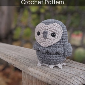 May include: Gray crocheted owl with black eyes and a beige beak. The owl is sitting on a wooden surface. - Gray Owl - Crochet Pattern