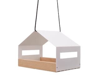 May include: White bird feeder shaped like a house with a wooden base and a black cord for hanging.