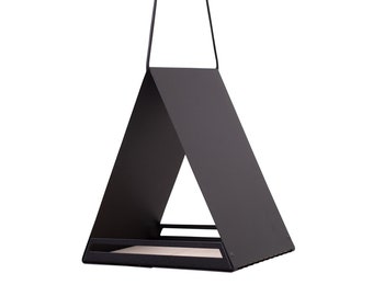 May include: A black metal bird feeder shaped like a triangular house with a small platform for food. The feeder hangs from two black cords.