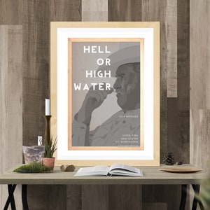 May include: A framed movie poster with a black and white image of a man wearing a cowboy hat. The poster is titled "Hell or High Water" and features the names Jeff Bridges, Chris Pine, Ben Foster, and Gil Birmingham.