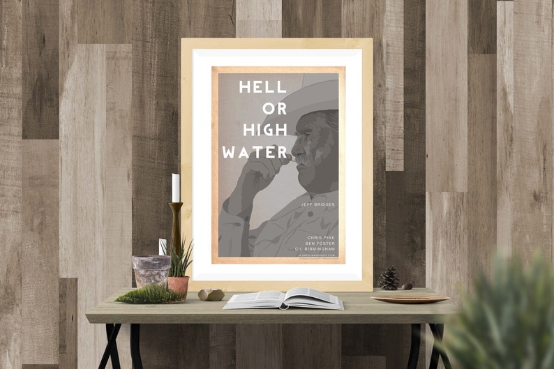 May include: A framed movie poster with a black and white image of a man wearing a cowboy hat. The poster is titled "Hell or High Water" and features the names Jeff Bridges, Chris Pine, Ben Foster, and Gil Birmingham.
