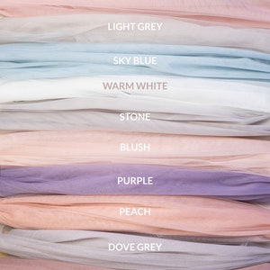 May include: A stack of tulle fabric swatches in various colors, including mocha, pink, light grey, sky blue, warm white, stone, blush, purple, peach, dove grey, and heather.