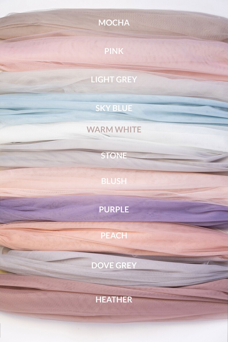 May include: A stack of tulle fabric swatches in various colors, including mocha, pink, light grey, sky blue, warm white, stone, blush, purple, peach, dove grey, and heather.