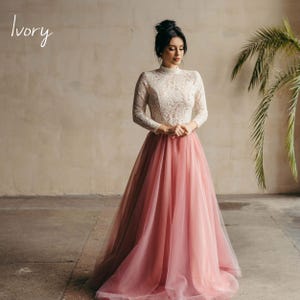 Ivory lace wedding blouse paired with blush pink tulle skirt, full-length bridal look.