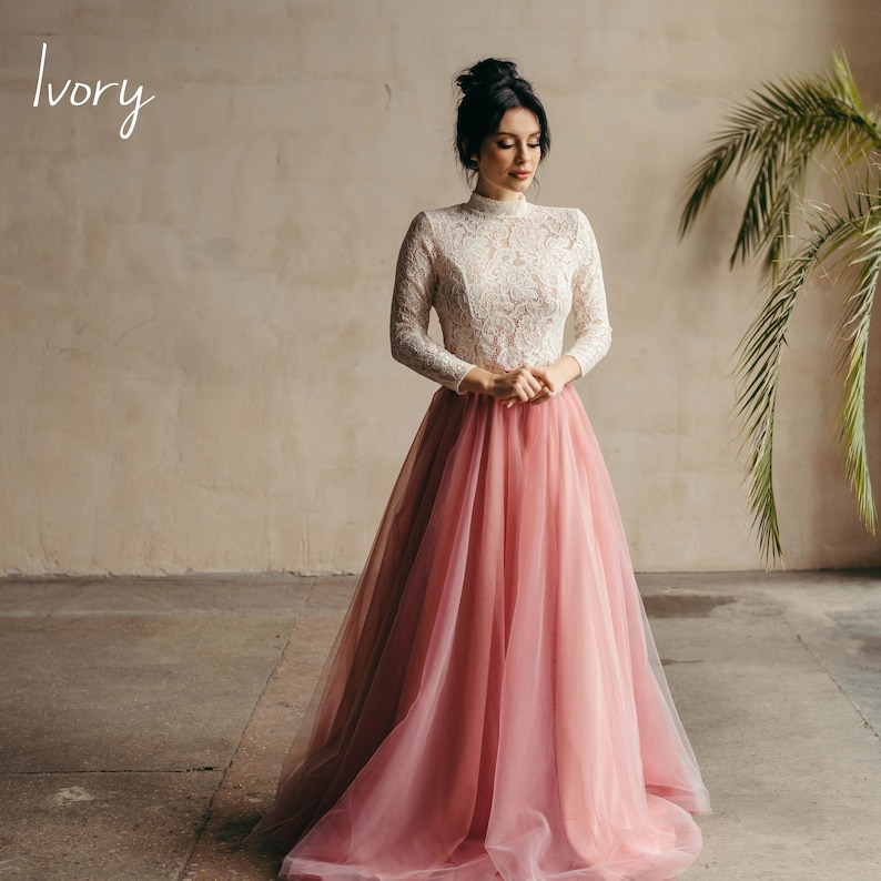 Ivory lace wedding blouse paired with blush pink tulle skirt, full-length bridal look.