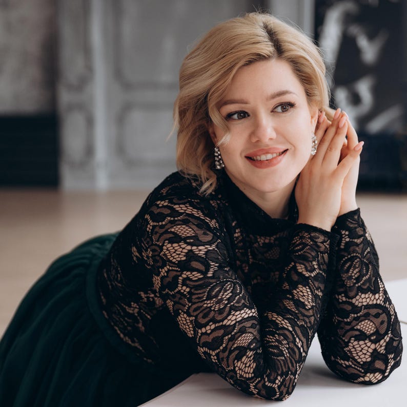 Bride wearing black lace wedding blouse, smiling close-up portrait.
