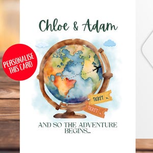 May include: A white card featuring a watercolour globe illustration with the names "Chloe & Adam" in green script. The globe has a plane graphic and two "TICKET" tags. The text "AND SO THE ADVENTURE BEGINS..." is below. A red circle says "PERSONALISE THIS CARD".