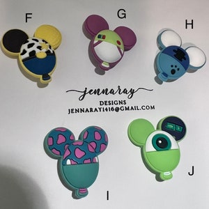 May include: Six colorful Mickey Mouse-shaped balloon charms with different designs. The charms are made of a soft, flexible material and are perfect for adding a touch of whimsy to your crafts or accessories.