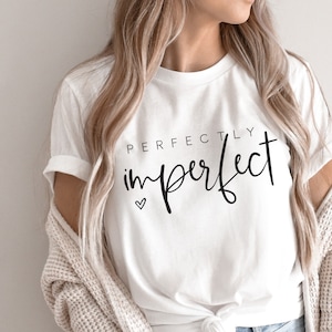May include: White t-shirt with the text "PERFECTLY imperfect" in black script with a small heart symbol.