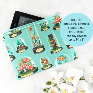 Puede incluir: Una bolsa de cremallera turquesa con un dise&ntilde;o caprichoso de hongos y plantas. La bolsa est&aacute; abierta para revelar un lector electr&oacute;nico negro con la palabra "kindle" impresa en el lateral. El texto "WILL FIT: KINDLE PAPERWHITE KINDLE OASIS FIRE 7 TABLET and any devices up to 6" x 8" est&aacute; impreso en la bolsa.