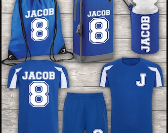 Op de afbeelding: Een blauwe voetbalset met een wit shirt, broekje en een trekkoordtas. Het shirt heeft de naam "Jacob" en het nummer "8" op de rug. Het broekje heeft het nummer "8" op het rechterbeen. De tas heeft de naam "Jacob" en het nummer "8" op de voorkant. De set bevat ook een blauwe schoenentas met de naam "Jacob" en het nummer "8" op de voorkant, en een waterfles met de naam "Jacob" aan de zijkant.