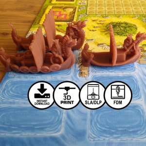 May include: Two brown plastic Viking longboats with a figurehead on the bow. The boats are on a blue game board with a grid pattern. The board has text that reads "LAGTBCICCIDS" and numbers 1, 1, 2, and 20. There are four circular icons below the boats that read "Instant Download", "3D Print", "SLA/DLP", and "FDM".