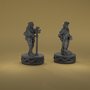 May include: Two gray painted miniature figures of people standing on round bases with a snake design. The figures are wearing clothing and carrying tools.