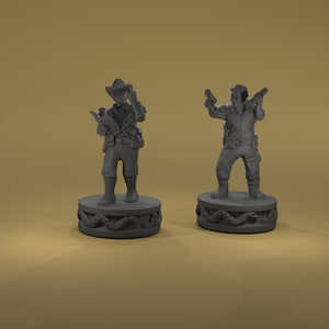 May include: Two gray painted miniature figures of people standing on round bases with a snake design. The figure on the left is wearing a hat and holding a book and a gun. The figure on the right is holding a gun in each hand.