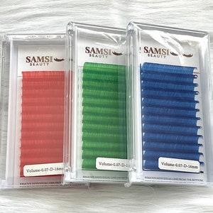 Könnte beinhalten: Drei transparente Kunststoffboxen mit SAMSI Beauty Volumenwimpern in Rot, Grün und Blau. Jede Box enthält eine Reihe einzelner Wimpern. Der Text auf den Boxen lautet "Volume-0.07-D-16mm".