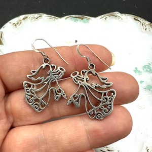 May include: A pair of silver dangle earrings featuring a delicate, intricate design of two stylised birds with openwork details.
